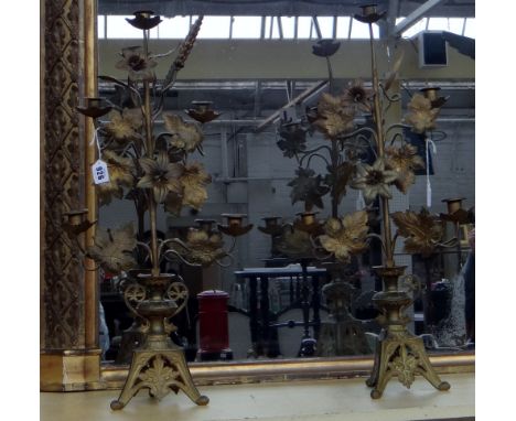A pair of Aesthetic Movement gilt metal five branch floral candelabra, late 19th century, each on a pierced triform base, (a.