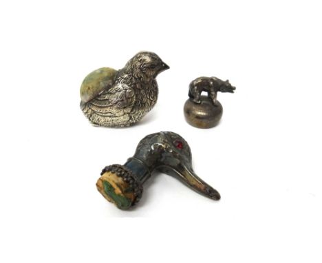 A silver pin cushion, modelled as a bird, Birmingham 1921, a plated bottle cork mount, modelled as the head of a duck with re