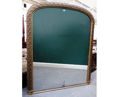 A Victorian gilt framed arch top overmantel mirror, the frame relief carved with oak leaves within a diamond lattice, 145cm w