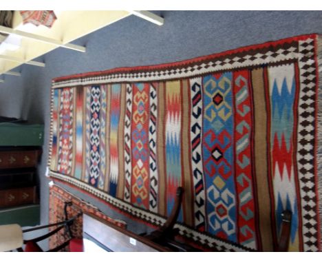 A Shiraz gelim, South Persian, the polychrome field with bands of design, an interconnecting arrow border, 322cm x 135cm.