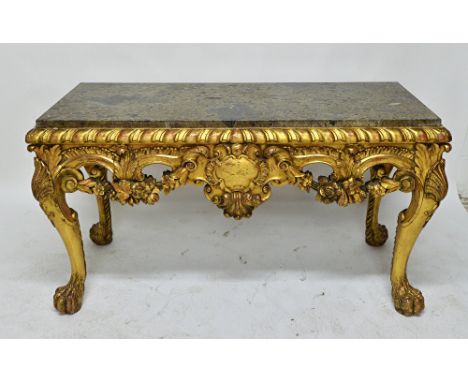 A George III style console table, the rectangular marble top over a carved and pierced giltwood base, centred by a cartouche,