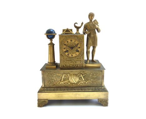 A French gilt metal mantel clock of Empire style, late 19th century, surmounted with a figure of a young boy reading a book, 