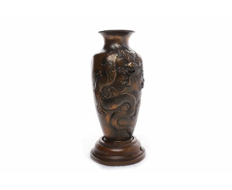 20TH CENTURY CHINESE COPPER VASEdecorated with two dragons holding the pearl, in relief, no base, on a (drilled) wooden stand