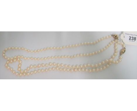 A single row cultured pearl necklace of uniform sized pearls to a 9ct gold clasp, together with another cultured pearl neckla
