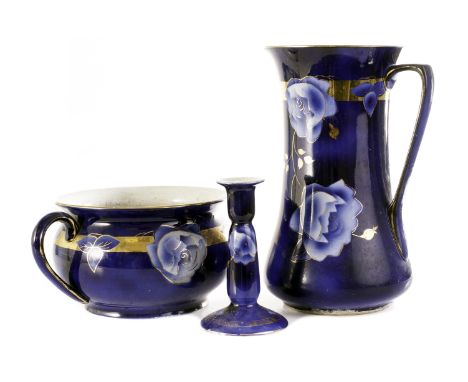 An Art Nouveau pottery wash set,  the dark blue ground with rose flower design, heightened in gilt, comprising wash basin, wa