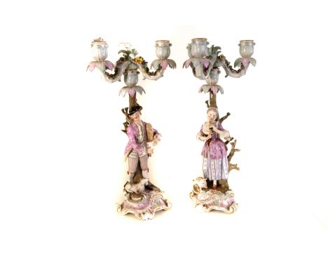 A pair of Meissen porcelain figural candle holders, the bodies of a male a female playing musical instruments, with three bra