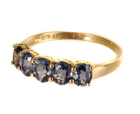 A 9ct gold five stone dress ring, the five oval cut stones of either tourmaline or bi-colour sapphire adjacently sent in a 9c