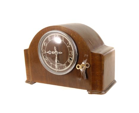 An Enfield domed walnut veneered mantle clock, with white Arabic numerals to face