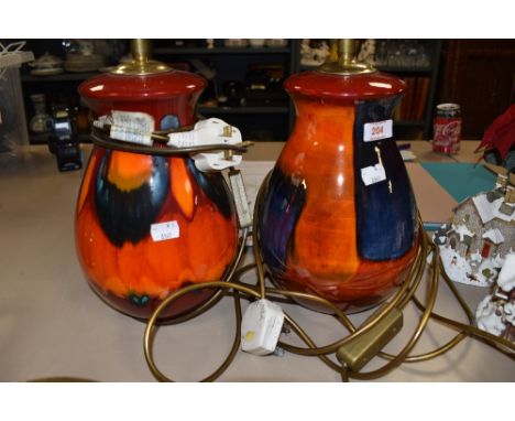 A pair of Poole pottery lamp bases in reds, oranges and blues having a slightly lustrous finish.
Both lamps in very good cond