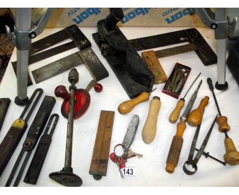 A selection of antique hand tools including a solid cast iron plane