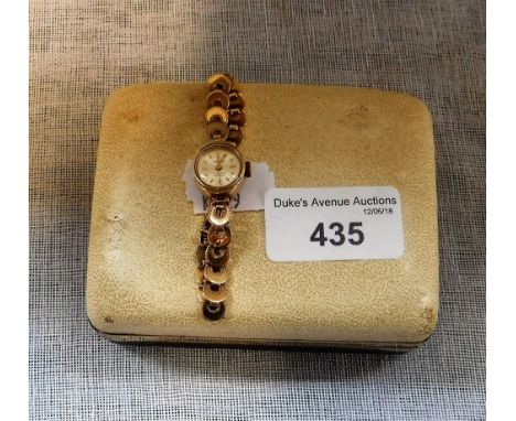 A LADIES 9CT YELLOW GOLD WRISTWATCH, the round dial with baton numerals inscribed 'Carronade'