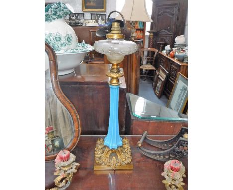 A VICTORIAN OIL LAMP with a blue glass column on an ormolu brass base, with a cut glass reservoir, 48 cm high (drilled for el