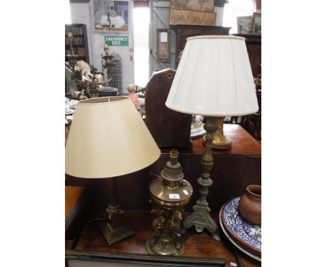 A VICTORIAN STYLE BRASS OIL LAMP, supported by rams (converted to electricity) and two similar table lamps (3)