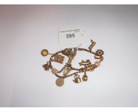 A YELLOW METAL FOB CHAIN, with attached yellow metal and 9ct yellow gold charms, with silver padlock