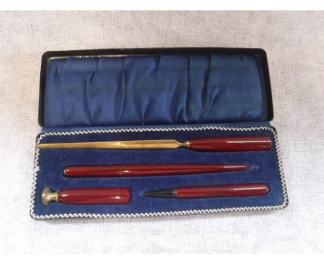 A VINTAGE RED BAKELITE DESK SET in a fitted presentation case 