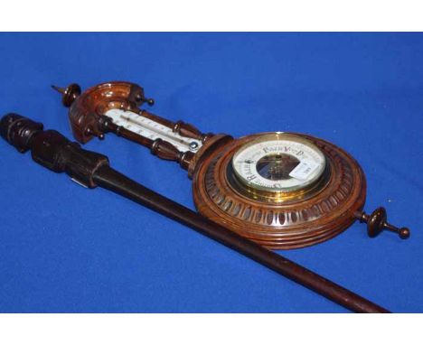 EARLY TWENTIETH CENTURY CARVED WALNUT BAROMETER 
with mercury thermometer in neck, together with a carved mahogany walking st