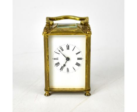An early 20th century French brass carriage clock, the white dial set with Roman numerals, crystal panel to the top with move