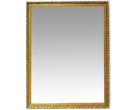 A large modern bevel edged rectangular wall mirror, the frame moulded with pomegranates and leaves, 102 x 133cm.