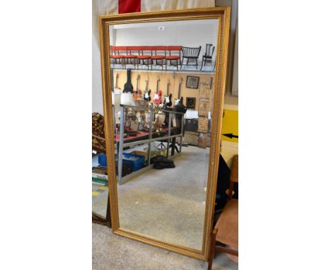 A large contemporary gilded bevel edge wall mirror, 87.5 x 176.5cm.