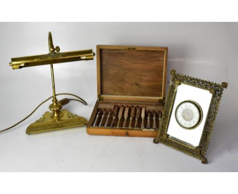 A mid-20th century Continental brass clock, the ivorine dial set with Arabic numerals, within an easel mirrored picture frame