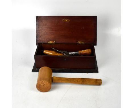 A mahogany box with hinged lid and raised brass lozenge-shaped detail, within a mahogany lozenge-shaped surround, containing 