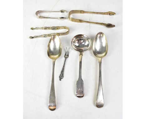 A pair of George III hallmarked silver dessert spoons, a Victorian ladle, three pairs of hallmarked silver sugar tongs and a 