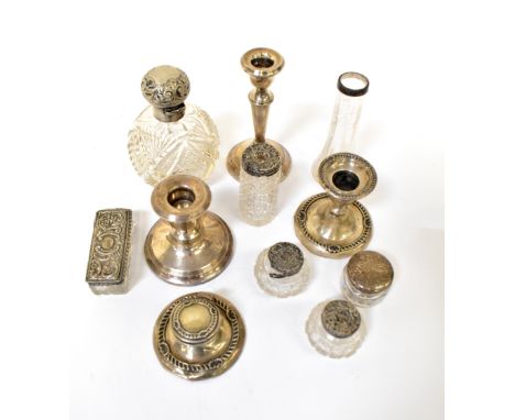 A small mixed lot of silver comprising a squat candlestick with matching capstan inkwell, a cut glass scent bottle with hallm