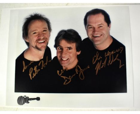 THE MONKEES; a colour photograph bearing the signatures of Peter Tork, Davy Jones and Mickey Dolenz, 20 x 25cm.We have not au