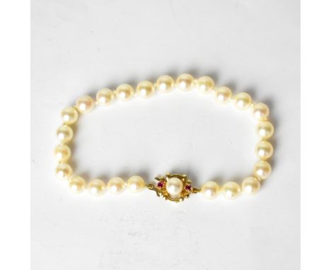 A cultured pearl bracelet with a 9ct yellow gold clasp set with single pearl and two small rubies.