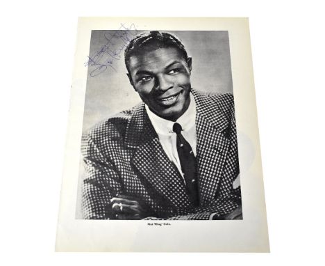 NAT KING COLE; a torn page with a black and white photograph, bearing his signature, 27 x 21cm.We have not authenticated this