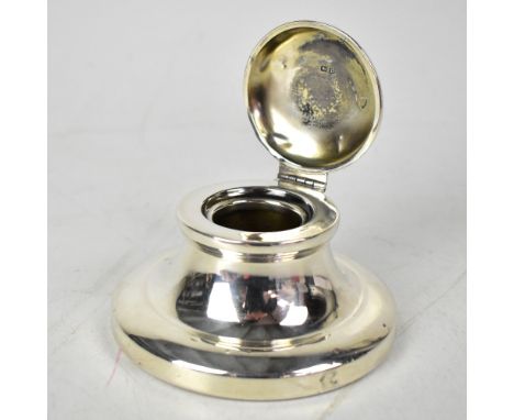 A George V hallmarked silver capstan inkwell, with hinged lid, on spreading circular base (lacking liner), Birmingham 1928, m