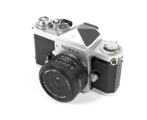 A silver Nikon F 35mm SLR eye level camera. With a 35mm 1:2.5 lens