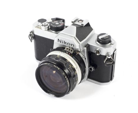 A silver Nikon FE 35mm SLR camera. With a 28mm 1:3.5 Nikkor-H Lens