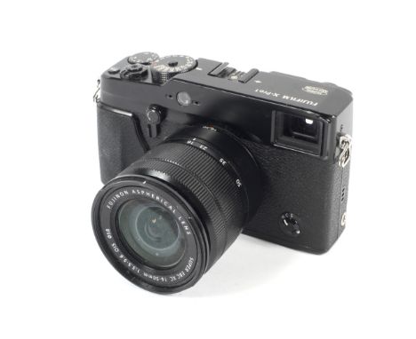 A Fujifilm X-Pro 1 mirrorless digital camera. With a 16-50mm 1:3.5-5.6 Fujinon Aspherical lens. Missing battery and charger C