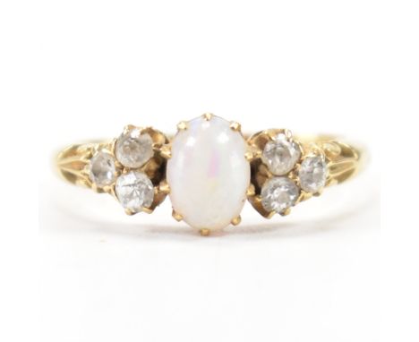 An antique 18ct gold opal and diamond ring. The ring being set with an oval opal cabochon flanked by six round cut diamonds o