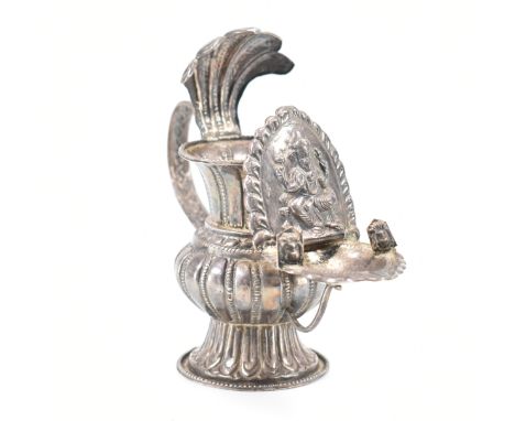 An antique Nepalese silver oil lamp Sukunda. The lamp having a bulbous body with flared rim and foot, having a scrolled handl