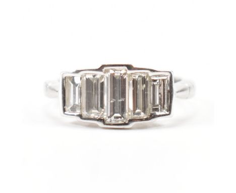 A white gold and diamond five stone ring. the ring being bezel set with five graduating rectangular cut diamonds. Band marked