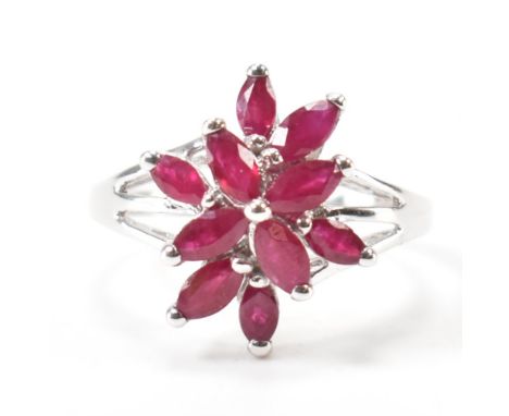 A hallmarked 9ct white gold &amp; ruby cluster ring. The ring having ten navette / marquise cut prong basket set rubies to do
