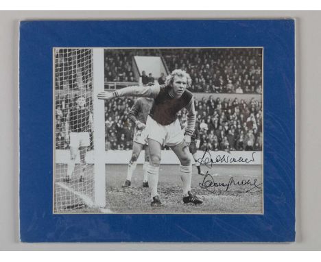 A black and white autographed photograph of Bobby Moore in West Ham kit