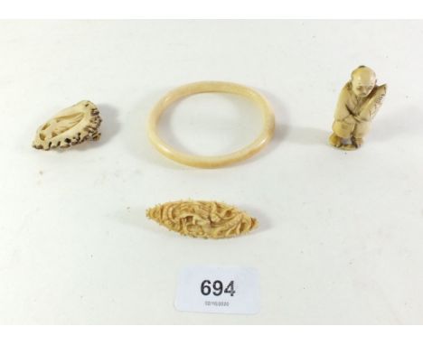 Two carved bone brooches, a 19thC Japanese ivory netsuke and an antique ivory bangle. 