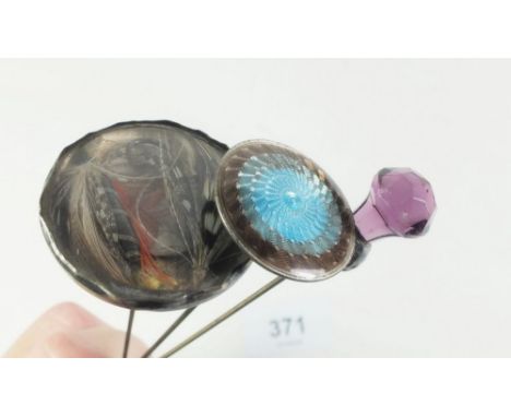 A silver and enamel hat pin, silver and purple glass thistle form one and a feather hat pin 