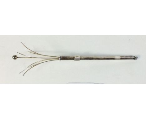 A silver swizzle stick 