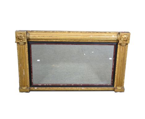Regency gilt wood and gesso overmantel mirror, rectangular plate, within an ebony reeded slip, the surround with fluted pilas