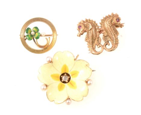 Three brooches. A 9 carat yellow gold double seahorse brooch, 20mm; Enamel flower in a 15mm frame; Yellow enamel flower with 