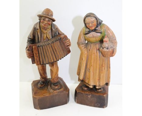 A PAIR OF BLACK FOREST TYPE CARVED SOFT WOOD PEASANT FIGURES, man with accordion, woman with hen, remains of polychrome decor