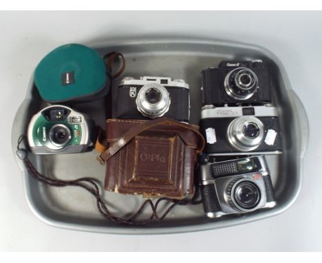 A Collection of 35 mm Cameras and A Canon Digital Camera.