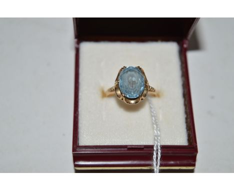 A light blue spinel ring, the oval facet cut stone six double claw set in openwork mount with beaded shoulders, on a 9ct. yel