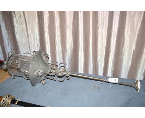 A metal hanging hall lantern with glass shade.