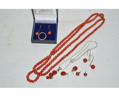 Coral jewellery, to include: a two-strand necklace with yellow metal clasp set coral cabochon; a pendant of three coral caboc
