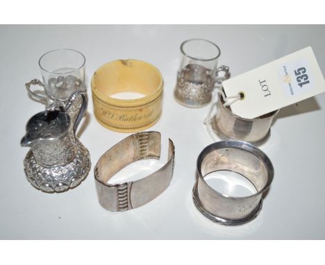 Two silver napkin rings with ribbon and pole decoration; a broken white metal napkin ring; a Victorian napkin ring with inscr